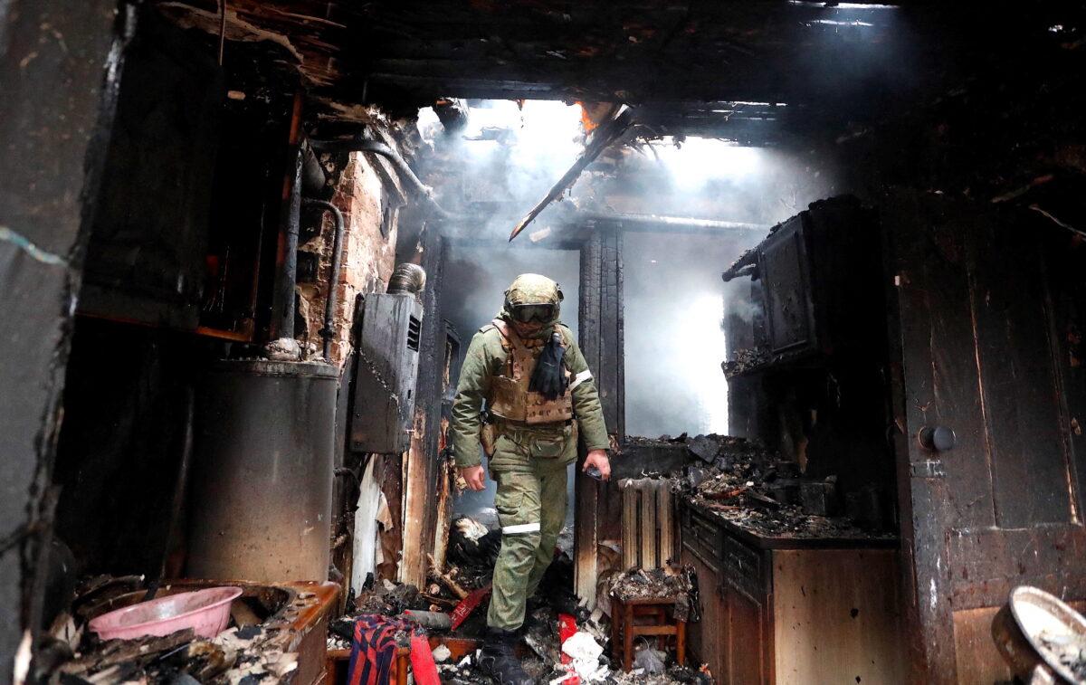 A member of a pro-Russian militia walks inside a house that was damaged by shelling, in the separatist-controlled city of Donetsk, Ukraine, on Feb. 28, 2022. (Alexander Ermochenko/Reuters)