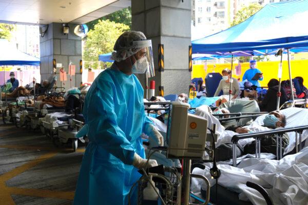 Patients in hospital beds wait in a temporary holding area outside Caritas Medical Centre in Hong Kong on March 2, 2022. (Kin Cheung/AP Photo)