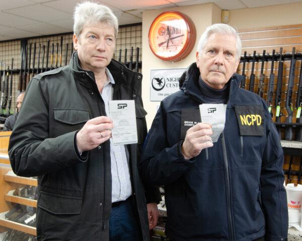 Nassau County Executive Bruce Blakeman (R) and Misha Migdal of the Ukrainian-American Chamber of Commerce, show off the receipts of their recently purchased assault rifles on March 3, 2022. (Dave Paone/The Epoch Times)