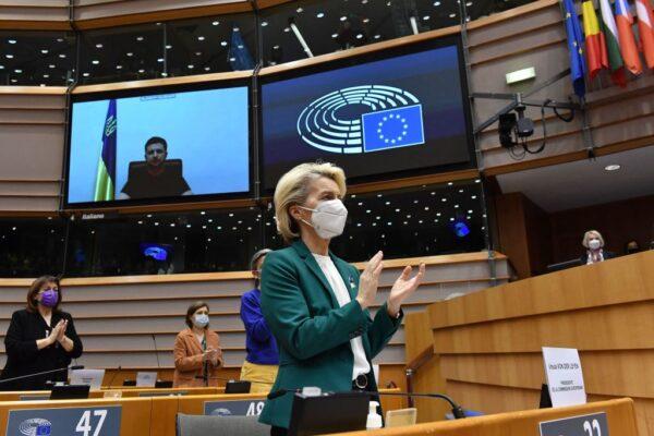 European Commission President Ursula von der Leyen (C) applauds Ukrainian President Volodymyr Zelenskyy (L) who appears on a screen as he speaks in a video conference during a special plenary session of the European Parliament focused on the Russian invasion of Ukraine at the EU headquarters in Brussels, Belgium, on March 1, 2022. (John Thys/AFP via Getty Images)