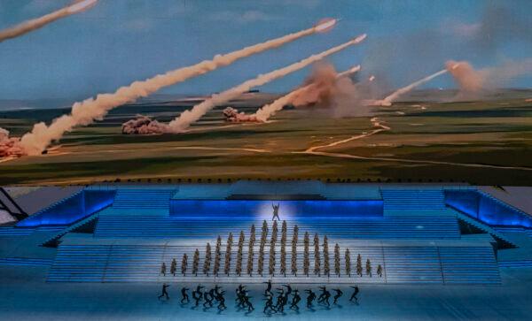 Performers dressed as military perform in front of a screen showing rockets being launched during a mass gala marking the 100th anniversary of the Chinese Communist Party at the Olympic Bird's Nest stadium in Beijing, China, on June 28, 2021. (Kevin Frayer/Getty Images)