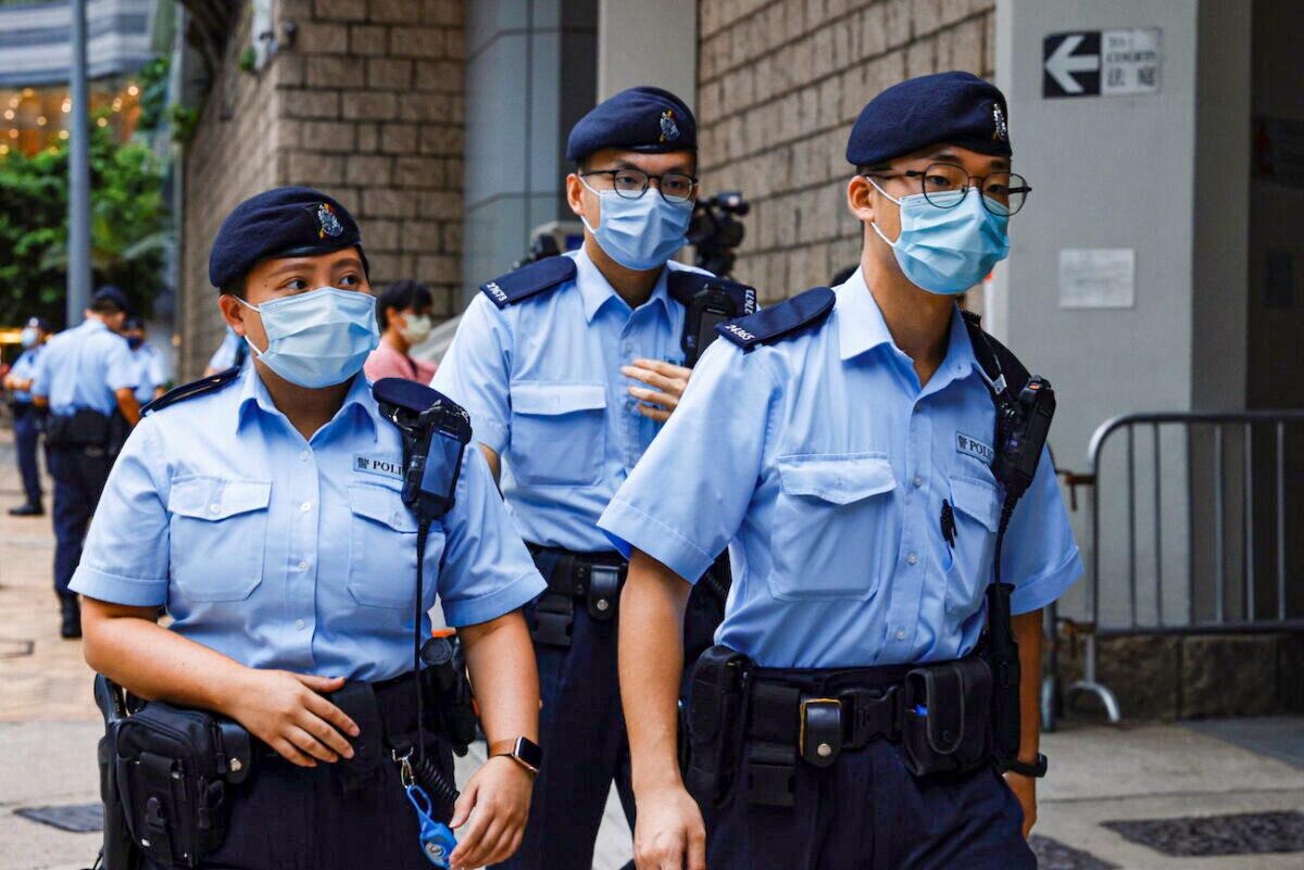 Police stand guard as a prison van arrives at the High Court on the first day of the trial of Tong Ying-kit, the first person charged under a new national security law, in Hong Kong on June 23, 2021. (Tyrone Siu/Reuters)