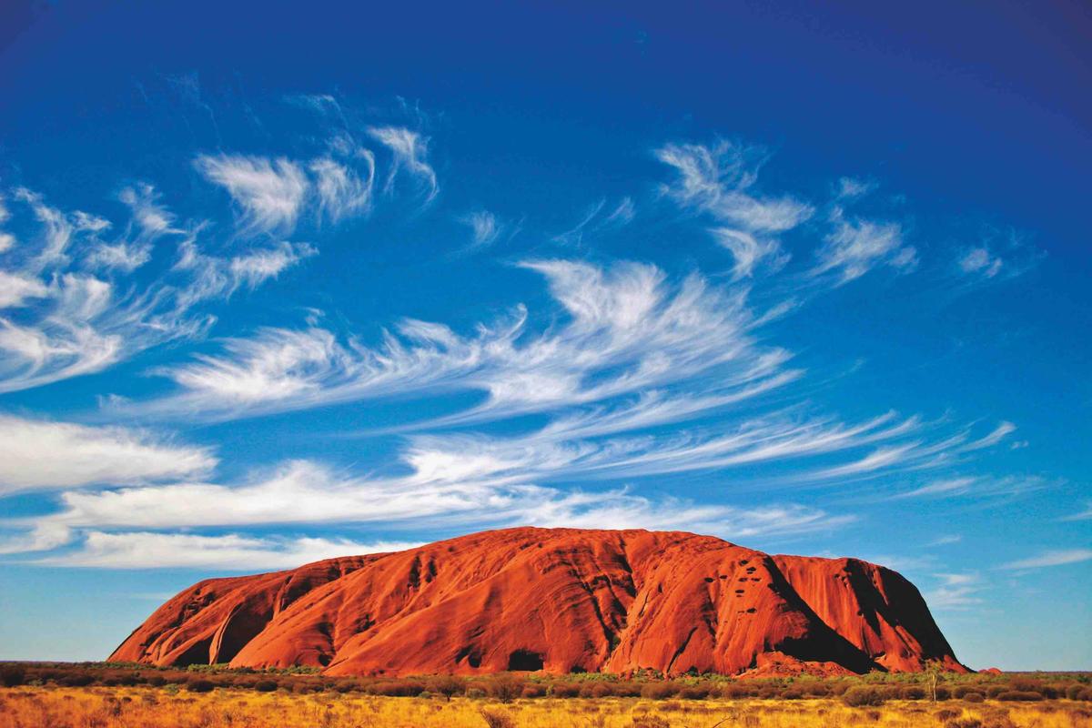 Uluru Ayers Rock with wispy clouds. (Stickybeak TV/Shutterstock)