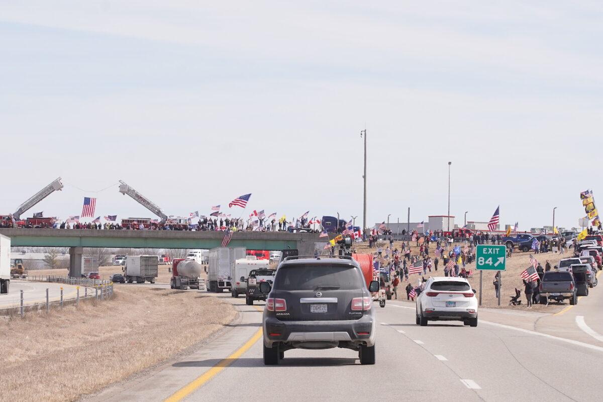 Crowds gather on and around an overpass in support of the trucker convoys passing through the area, in Missouri, on Feb. 28, 2022. (Enrico Trigoso/The Epoch Times)