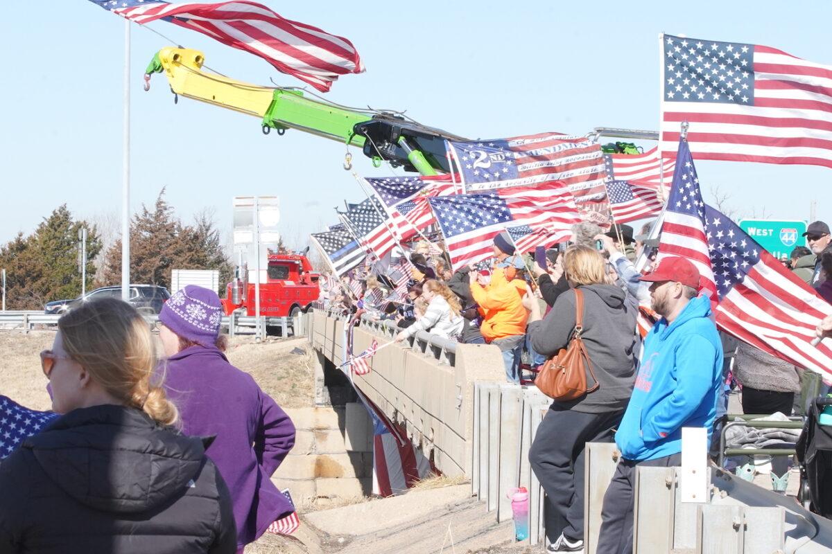 People gather at an overpass in St. Claire, Missouri, in support of the People's Convoy headed to Washington, on March 1, 2022. (Enrico Trigoso/The Epoch Times)