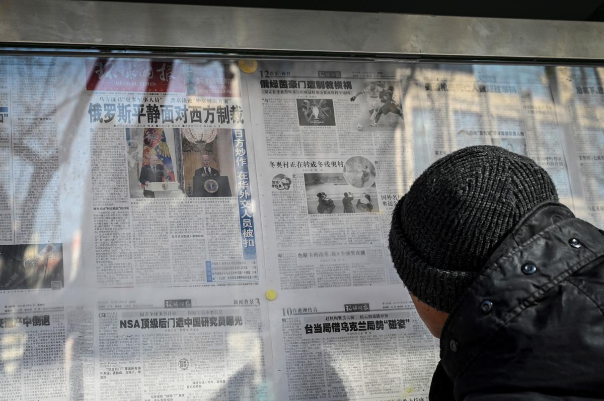 A man reads the Chinese state-run newspaper with coverage of the conflict between Russia and Ukraine, on a street in Beijing on Feb. 24, 2022. (Jade Gao/AFP via Getty Images)
