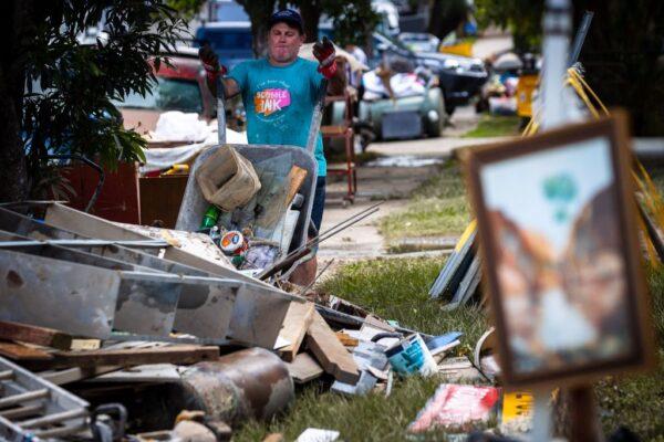 A resident discards items in the flood-damaged suburb of Newmarket in Brisbane on March 1, 2022. (Photo by Patrick HAMILTON / AFP) (Photo by PATRICK HAMILTON/AFP /AFP via Getty Images)
