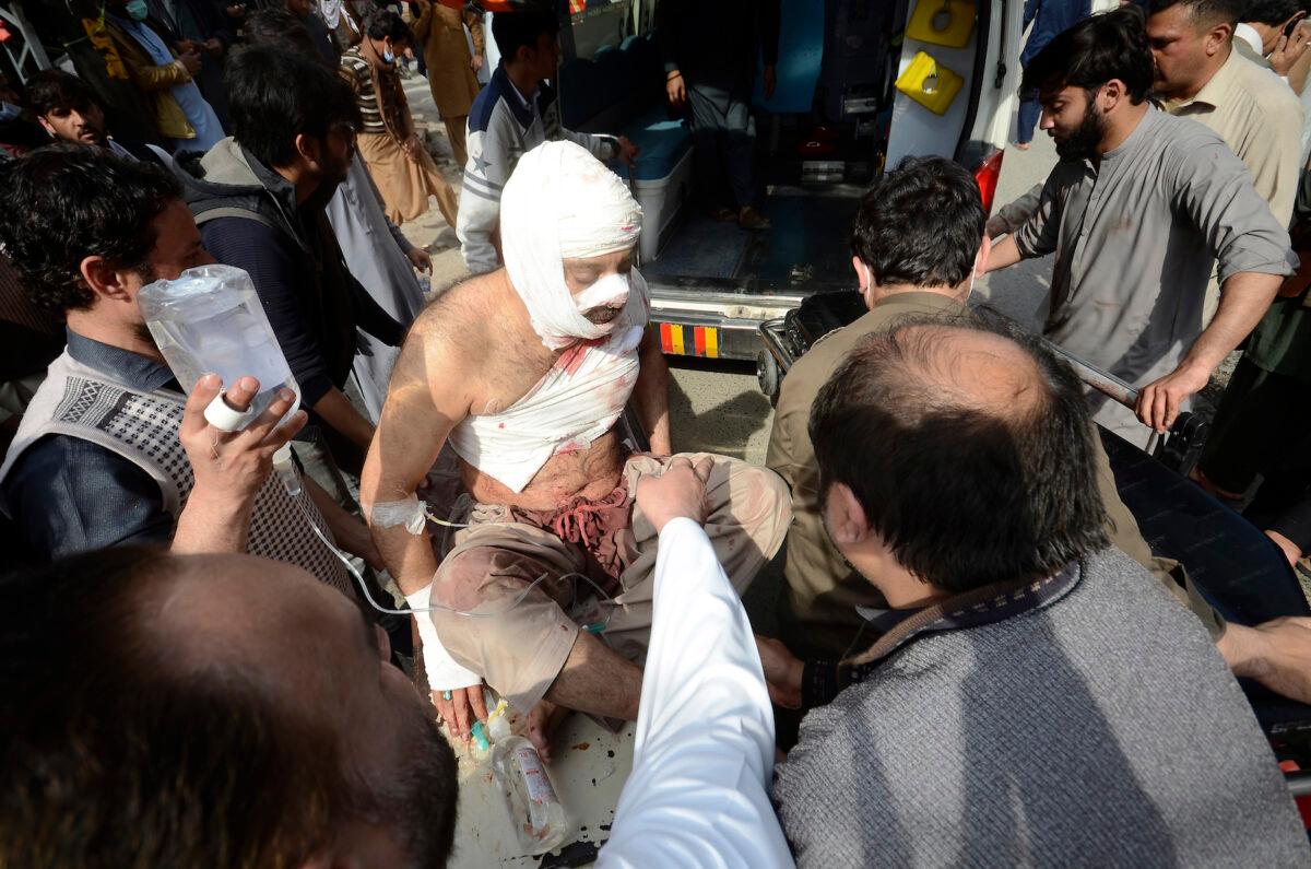 Volunteers transport an injured victim of a bomb explosion at a hospital in Peshawar, Pakistan, on March 4, 2022. (Muhammad Sajjad/AP Photo)
