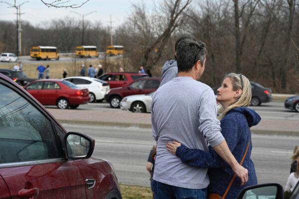 Holly and Eric Thompson wait as students from Olathe East High School are evacuated from the school, in Olathe, Kan., on March 4, 2022. (Reed Hoffmann/The Kansas City Star via AP)