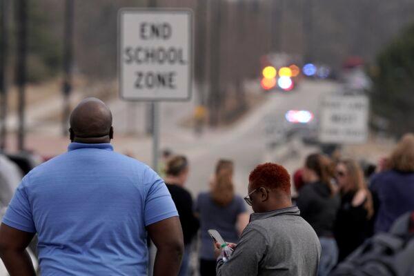 Parents wait at a nearby staging area for their students to be released from Olathe East High School after a shooting at the school, in Olathe, Kan., on March 4, 2022. (Charlie Riedel/AP Photo)