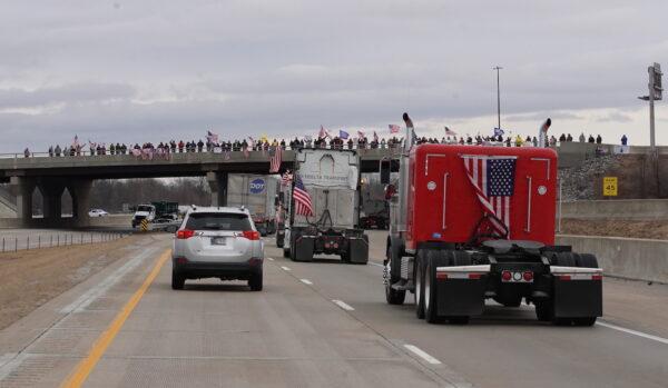Supporters wave U.S. flags from an overpass in support of The People's Convoy traveling from Indiana to Lore City, Ohio, on March 3, 2022. (Enrico Trigoso/The Epoch Times)
