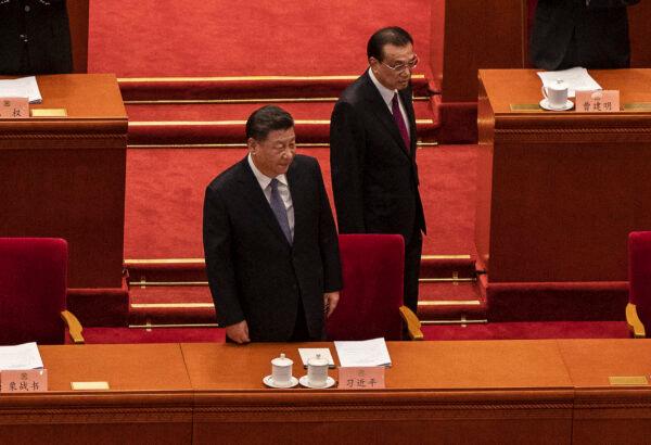Chinese President Xi Jinping (C) prepares to take his seat as he arrives with Premier Li Keqiang at the opening session of the Chinese Peoples Political Consultative Conference at the Great Hall of the People in Beijing, China, on March 4, 2022. (Kevin Frayer/Getty Images)