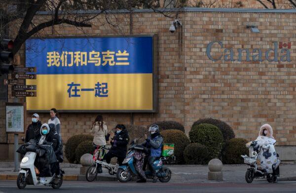 A large Ukranian flag with the slogan ‘We Stand With Ukraine’ written on it in Chinese characters is seen on the outside wall of the Canadian Embassy in Beijing on March 1, 2022. (Kevin Frayer/Getty Images)