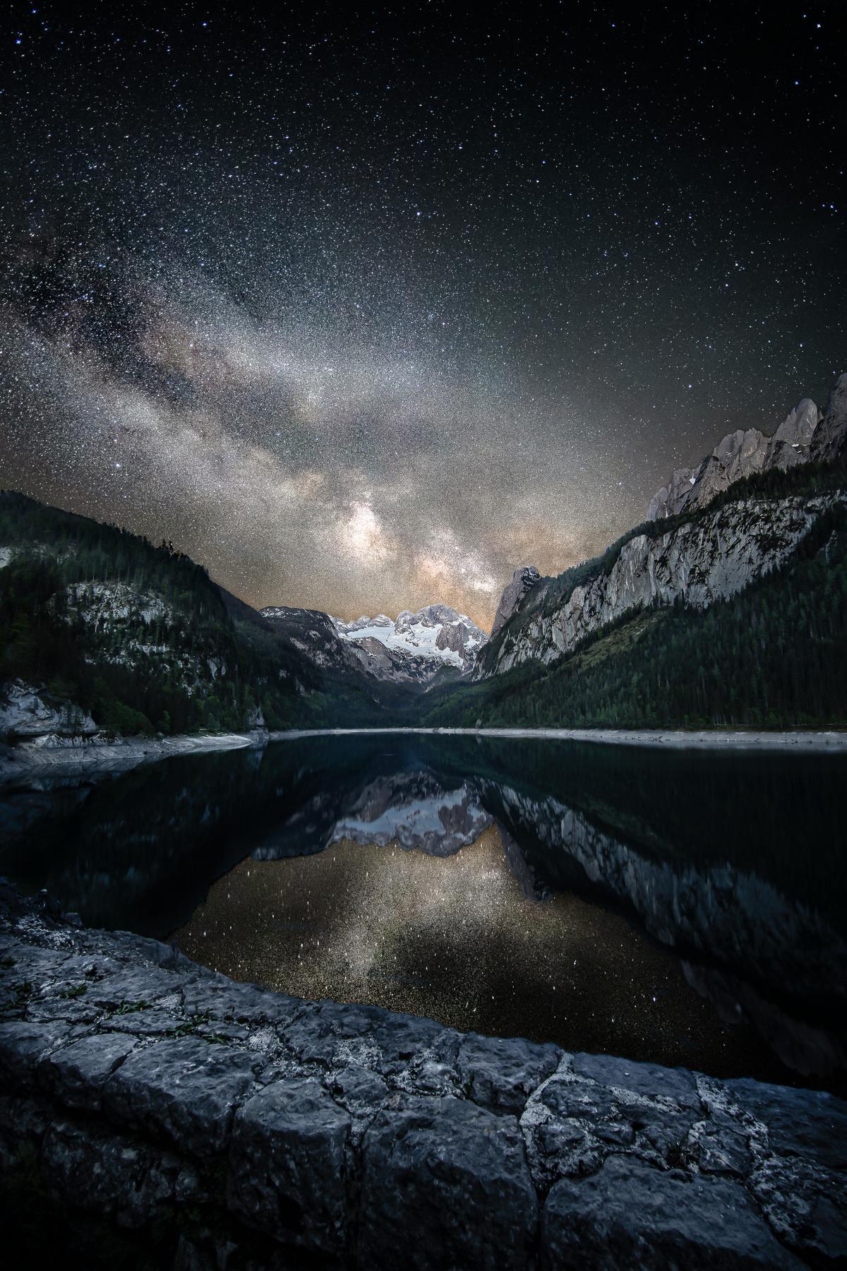 "Milky Way in Salzkammergut" by Sonja Ivancsics, Austria; "I planned this photo for about a year, and on that night in June 2021 the conditions were just perfect. The Gosausee lake in Salzkammergut reflects its surrounding mountains beautifully, especially the mountain Dachstein with its glacier. The picture blends two images, one taken in the blue hour, and one taken at about midnight." (© Sonja Ivancsics, Austria, Winner, National Awards, Landscape, 2022 Sony World Photography Awards)