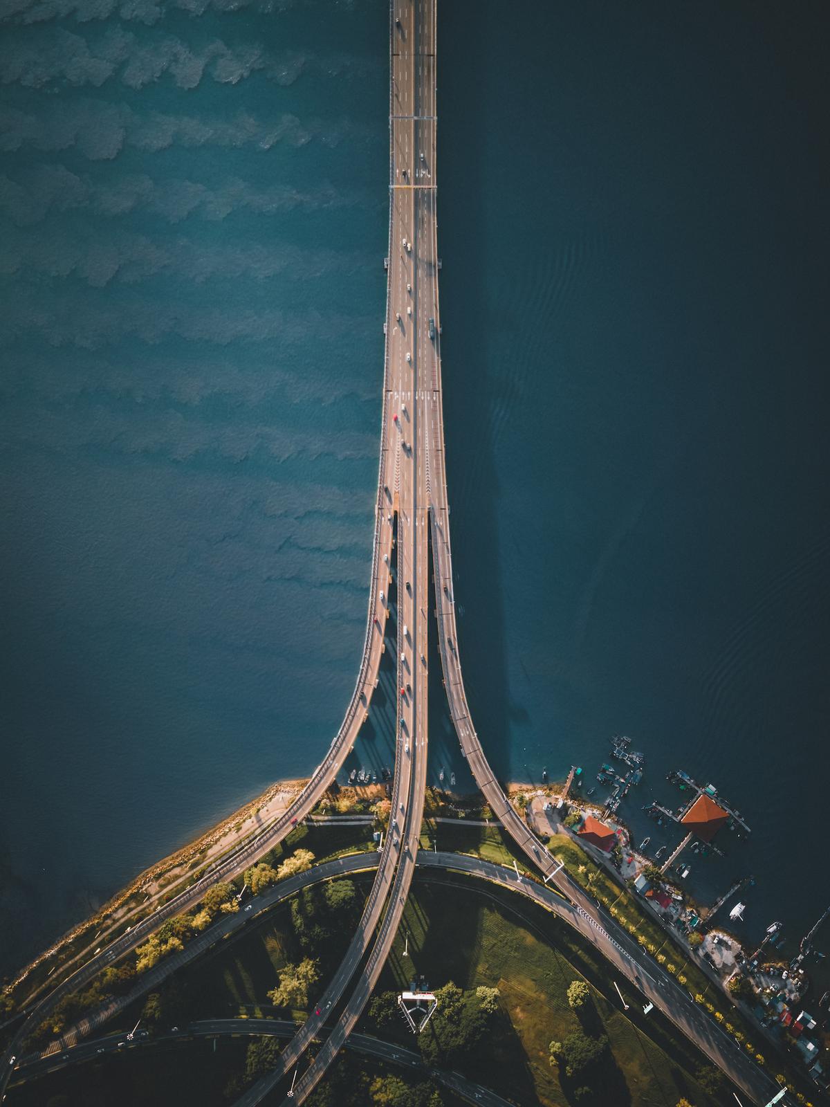 "A Top Down View of Penang’s First Bridge" by Yih Chang Chew, Malaysia; "The 13.5-km Penang bridge highway is the second-longest bridge in Malaysia. It was built in 1985 and until 2014 it was the only road connection between Peninsular Malaysia and Penang Island. Here it’s seen from the island end." (© Yih Chang Chew, Malaysia, Winner, National Awards, Architecture, 2022 Sony World Photography Awards)