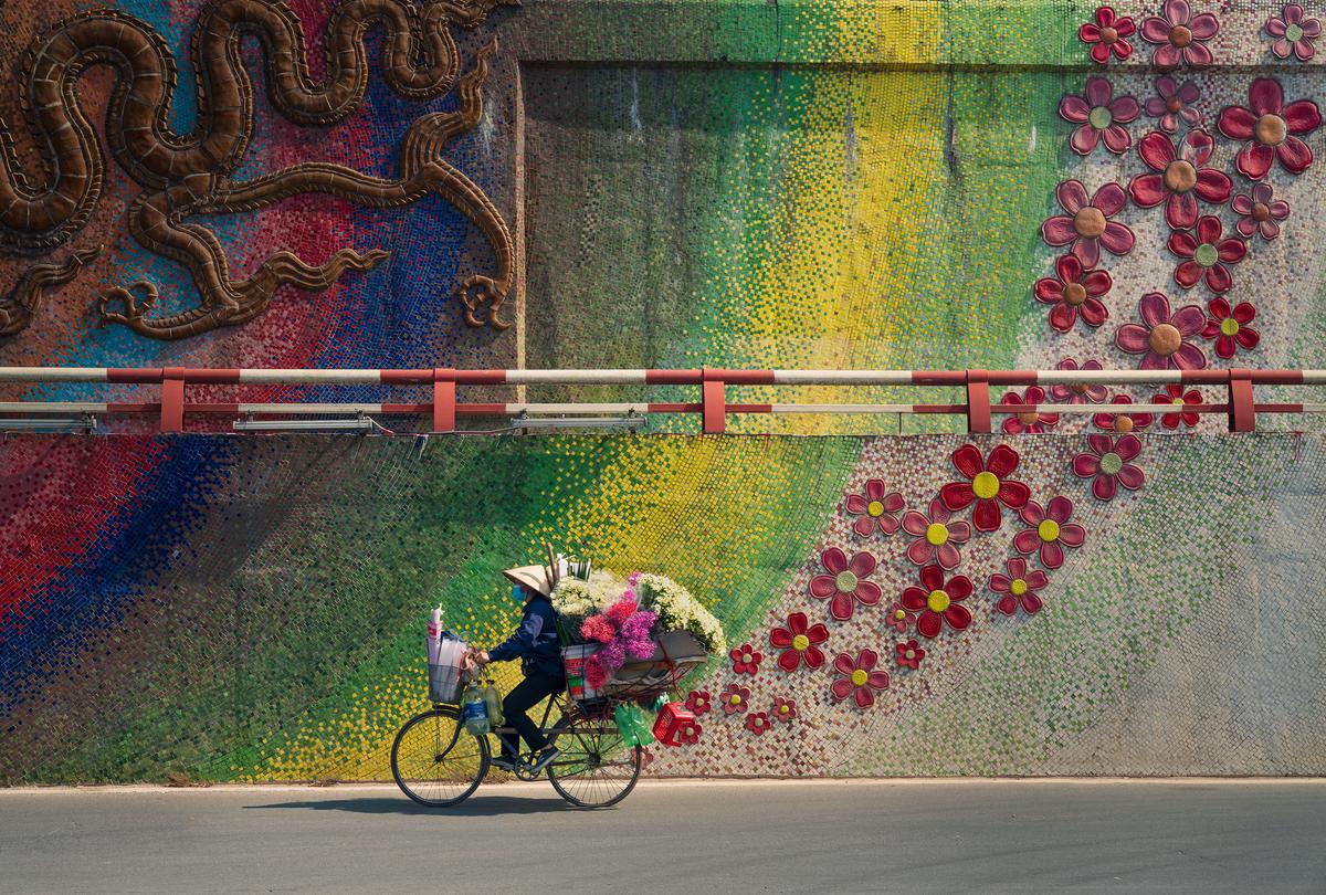 "Bike with Flowers" by Thanh Nguyen Phuc, Vietnam; "A hundred years ago there were just 36 streets and now there are many more, but the street culture remains strong in Hanoi. There are lots of shops in the main streets but people in the old streets prefer to get serviced by mobile street vendors. I spent a weekend following street vendors and found that they were walking or riding their bikes all day. Here is one of my favorite moments." (© Thanh Nguyen Phuc, Vietnam, Winner, National Awards, Travel, 2022 Sony World Photography Awards)