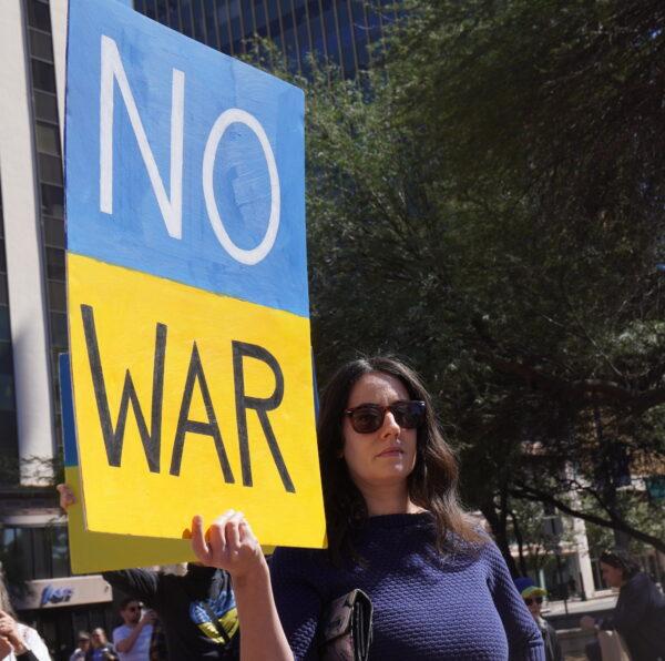 Angela Donofrio of Tucson, Ariz., hoists a sign calling for an end to the Russian invasion of Ukraine at a rally in Tucson on March 6. (Allan Stein/The Epoch Times)