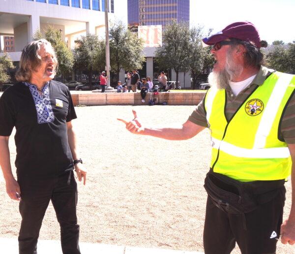 An organizer of a pro-Ukraine rally (L) in Tucson, Ariz., on March 6 confronts a counter-protester, who accuses Russian President Vladimir Putin and Ukrainian President Volodomyr Zelensky of both being puppets of the World Economic Forum, a globalist organization. (Allan Stein/The Epoch Times)