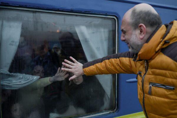 A father cries as he says goodbye to his family in front of an evacuation train at the central train station in Odessa on March 7, 2022. (Bulent Kilic/AFP via Getty Images)