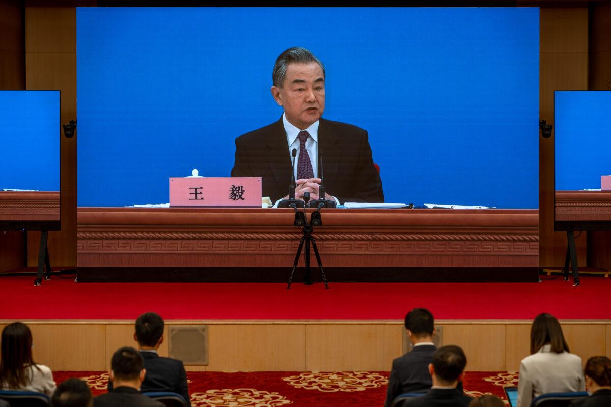 Chinese Foreign Minister Wang Yi is seen on large screens as he holds a press conference at the Media Center in Beijing on March 7, 2022. (Andrea Verdelli/Getty Images)