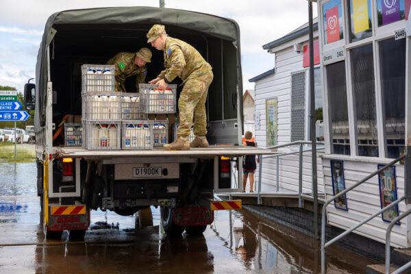 Australian Army soldiers from the 41st Battalion, Royal New South Wales Regiment, unload crates of refrigerated milk as part of Operation Flood Assist 2022 in Ulmarra, Australia, on March 2, 2022. (Australian Defence Force)