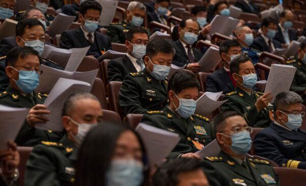 Attendees, many from the Chinese military, listen in the gallery at the opening session of the rubber-stamp legislature’s congress in Beijing, China on March 5, 2022. (Kevin Frayer/Getty Images)