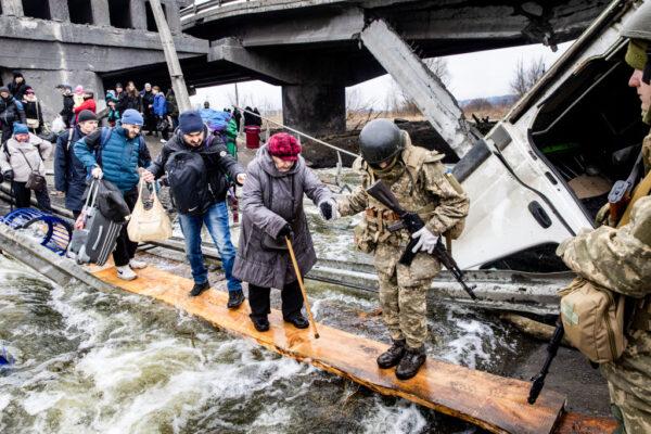 Residents flee heavy fighting via a destroyed bridge as Russian forces entered Irpin, Ukraine, on March 7, 2022. (Chris McGrath/Getty Images)