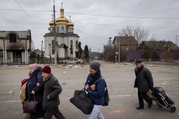 Residents of Irpin, fleeing heavy fighting, pass a church that was shelled after Russian forces entered the Ukrainian city on March 7, 2022. (Chris McGrath/Getty Images)