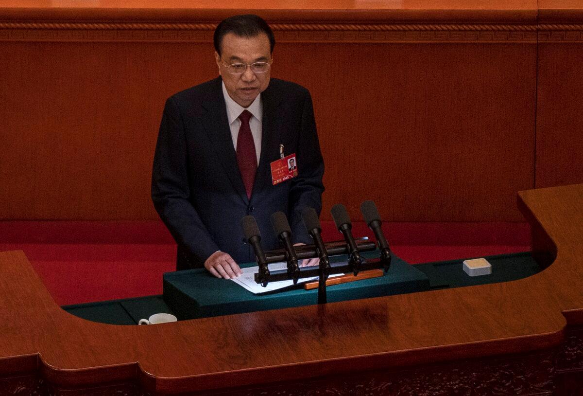 Chinese Premier Li Keqiang speaks from the podium at the opening session of the National Peoples Congress at the Great Hall of the People in Beijing, China, on March 5, 2022. (Kevin Frayer/Getty Images)