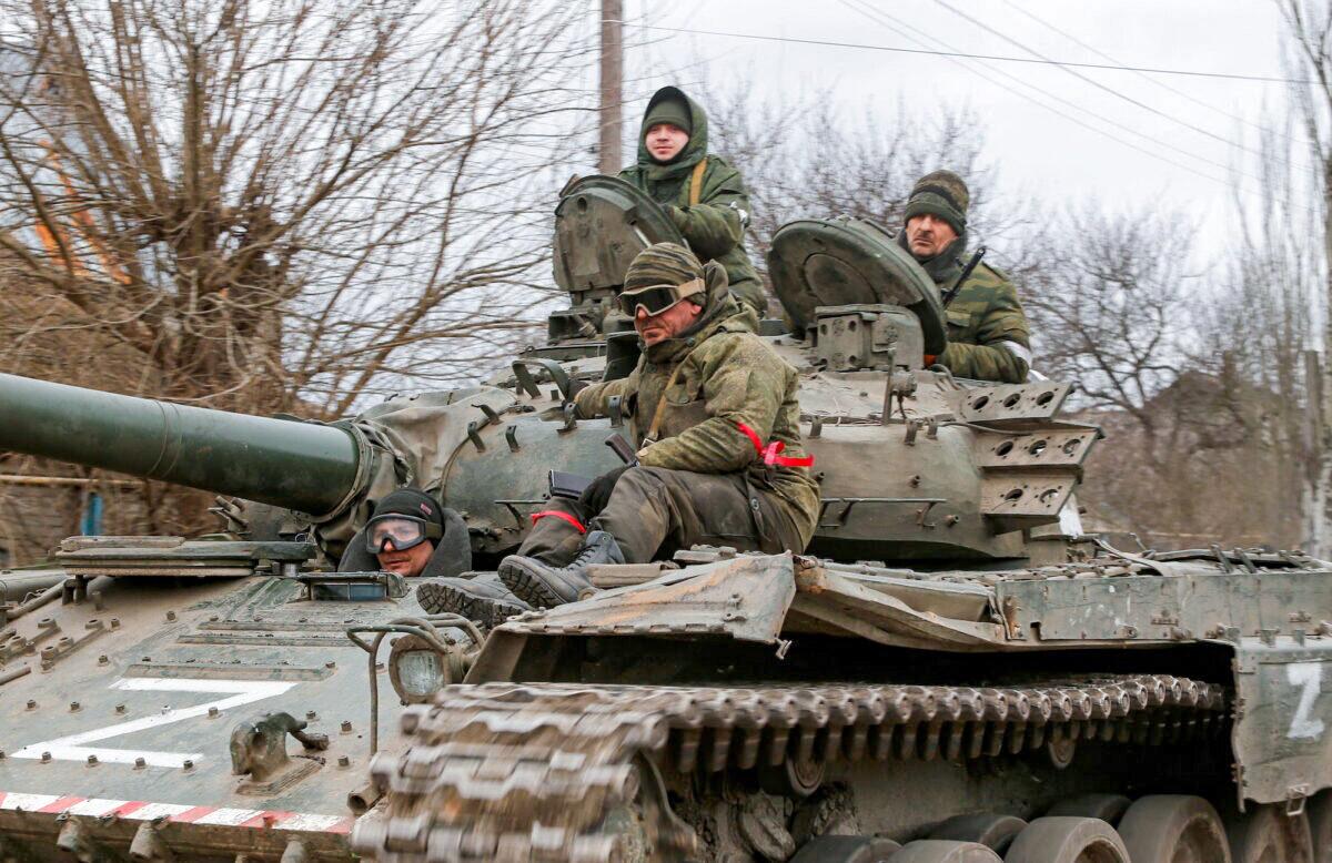 Service members of pro-Russian troops in uniforms without insignia are seen atop of a tank with the letter "Z" painted on its sides in the separatist-controlled settlement of Buhas (Bugas), in the Donetsk region, Ukraine, on March 1, 2022. (Alexander Ermochenko/Reuters)