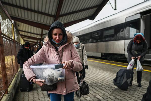 A woman carries a pet rabbit as she exits a train arriving from Kyiv, Ukraine, at Przemysl main train station in Poland on Feb. 23, 2022. (Omar Marques/Getty Images)