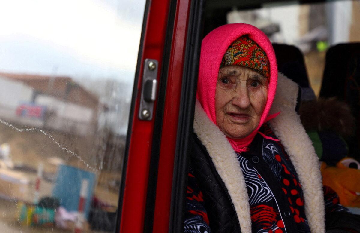 An 83-year-old Ukrainian woman looks out of a shuttle bus after crossing the border from Ukraine to Poland after fleeing from Mykolajiw, at the border checkpoint in Medyka, Poland, on March 8, 2022. (Fabrizio Bensch/Reuters)