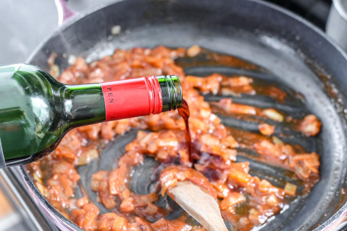 Stir the tomato paste, brandy (or cognac), wine, and bay leaf into your onions and garlic, making sure to scrape the bottom of the pan. (Audrey Le Goff)