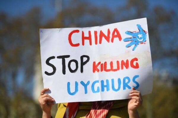 A member of the Uyghur community holds a placard in London on April 22, 2021. (Justin Tallis/AFP via Getty Images)