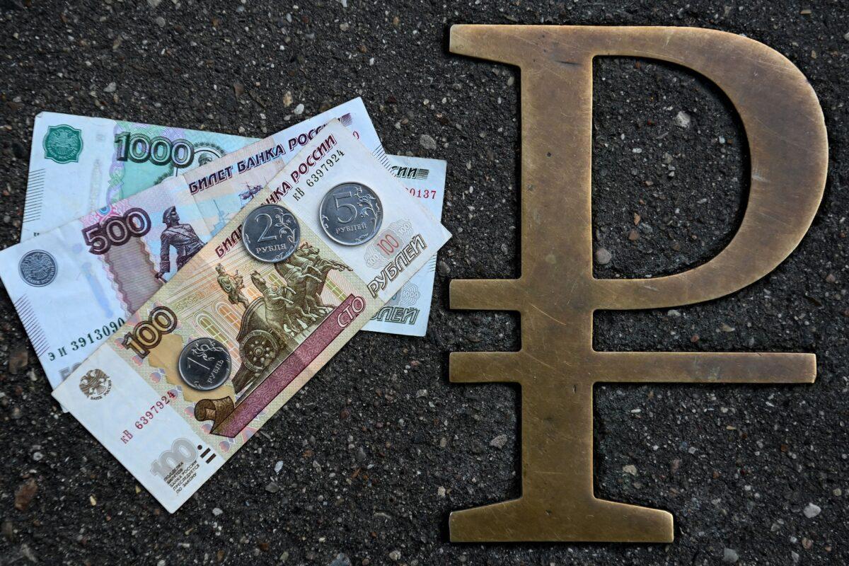 This picture taken on Aug. 13, 2021, in Moscow, shows Russian ruble coins and banknotes pictured next to a Russian ruble sign. (Kirill Kudryavtsev/AFP via Getty Images)