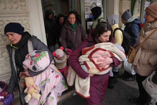  Women and children who have fled war-torn Ukraine emerge from the main railway station near the Ukrainian border in Przemysl, Poland, on March 9, 2022. (Sean Gallup/Getty Images)