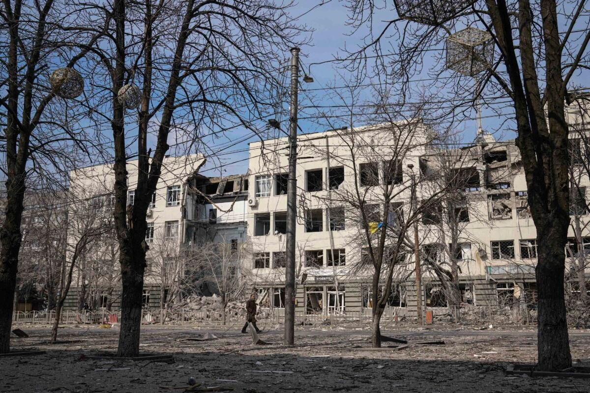 A man walks past a building that was damaged by shelling in Mira Avenue (Avenue of Peace) in Mariupol, Ukraine, on March 20, 2022. (Evgeniy Maloletka/AP)