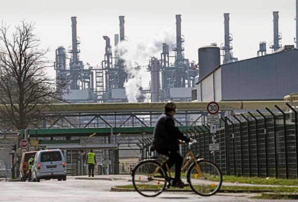 A worker rides his bicycle to the BP oil refinery Ruhr Oil in Gelsenkirchen, Germany, on March 28, 2022. (Martin Meissner/AP Photo)