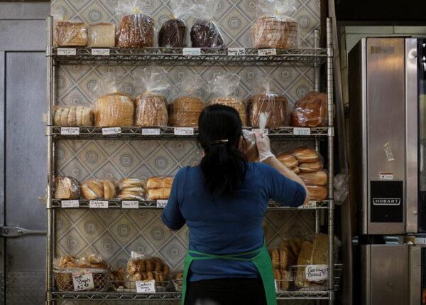 A baker stocks shelves with bread at the Eastern Market in Washington, on Feb. 11, 2022. (Brendan McDermid/Reuters)