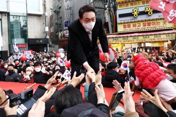 Yoon Suk-yeol, the presidential election candidate of South Korea's main opposition People Power Party (PPP), shakes hands with his supporters during his election campaign in Seoul, South Korea, on March 1, 2022. (Kim Hong-Ji/Reuters)