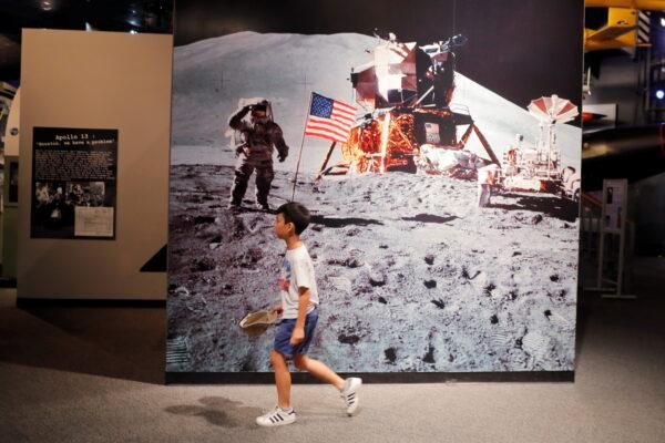A young boy walks past a photograph of Buzz Aldrin on the surface of the moon during the Apollo 11 mission at the Cradle of Aviation Museum in New York on July 17, 2019. (Lucas Jackson/Reuters)