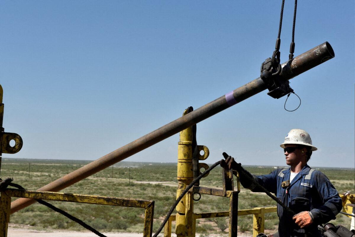 A drilling crew member raises drill pipe onto the drilling rig floor on an oil rig in the Permian Basin near Wink, Texas, on Aug. 22, 2018. (Nick Oxford/Reuters)