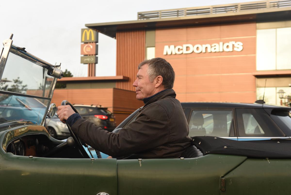 Mark pictured in his 1931 Alvis by a McDonald's. (Courtesy of Caters News)