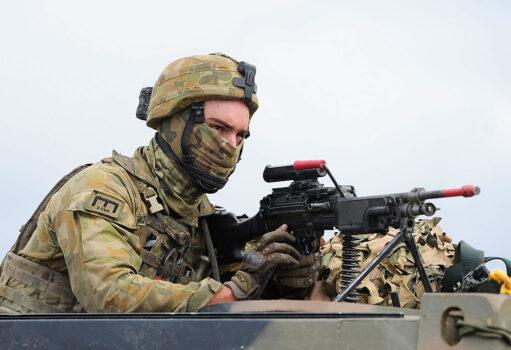 An Australian soldier from 7 Brigade operates a machine gun through the turret of a truck as part of exercise Talisman Sabre in Rockhampton, Australia, on July 9, 2015. (Ian Hitchcock/Getty Images)