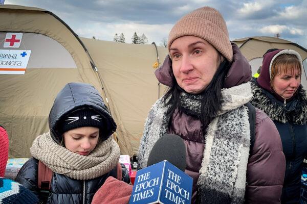Ukrainian refugees Anna Gorpenich and her children wait for a bus after arriving in Poland through the Medyka border crossing on March 10, 2022. (Charlotte Cuthbertson/The Epoch Times)