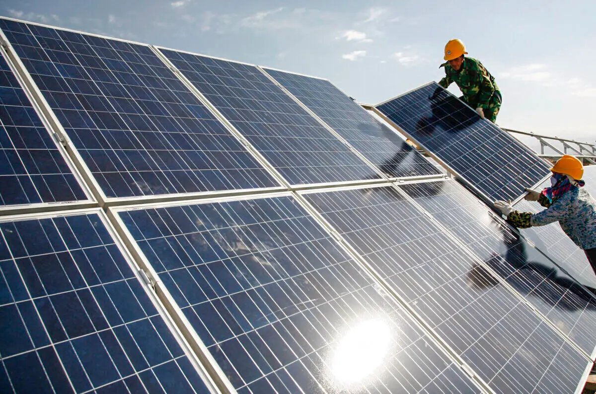 Workers install solar panels at a photovoltaic power station in Hami, northwestern China's Xinjiang Uyghur Autonomous Region, on Aug. 22, 2011. (Chinatopix via AP)