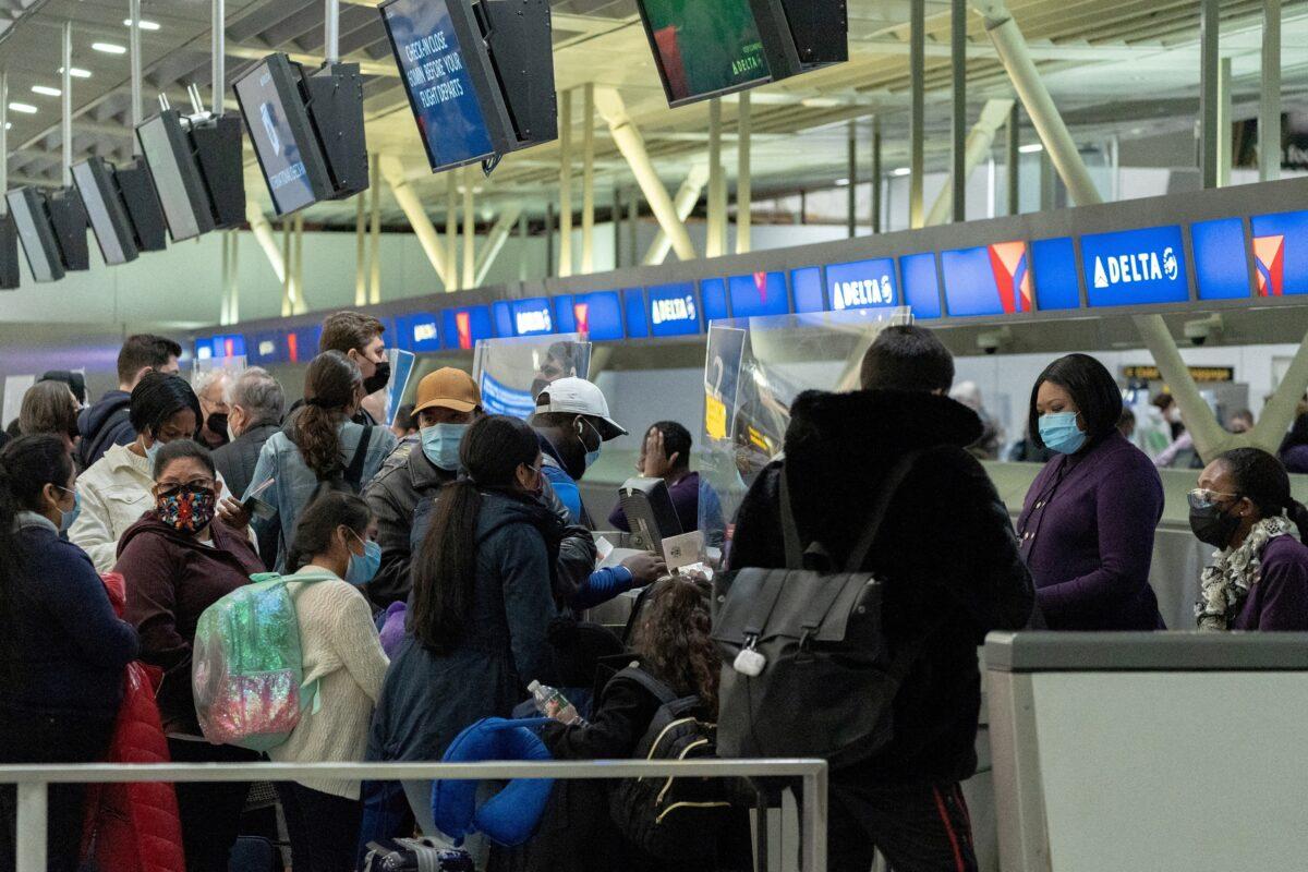 Travelers check in at John F. Kennedy International Airport in New York City on Dec. 26, 2021. (Jeenah Moon/Reuters)