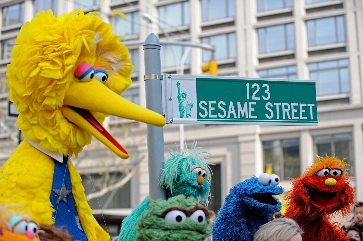 Big Bird (L) and other Sesame Street puppet characters pose next to a temporary street sign at West 64th Street and Broadway in N.Y., on Nov. 9, 2009. (Stan Honda/AFP via Getty Images)