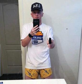 Micajah J. Jackson posted this selfie on social media, shown wearing "AK-style" shorts and pointing a handgun at the mirror. (U.S. Department of Justice / Screenshot via The Epoch Times)