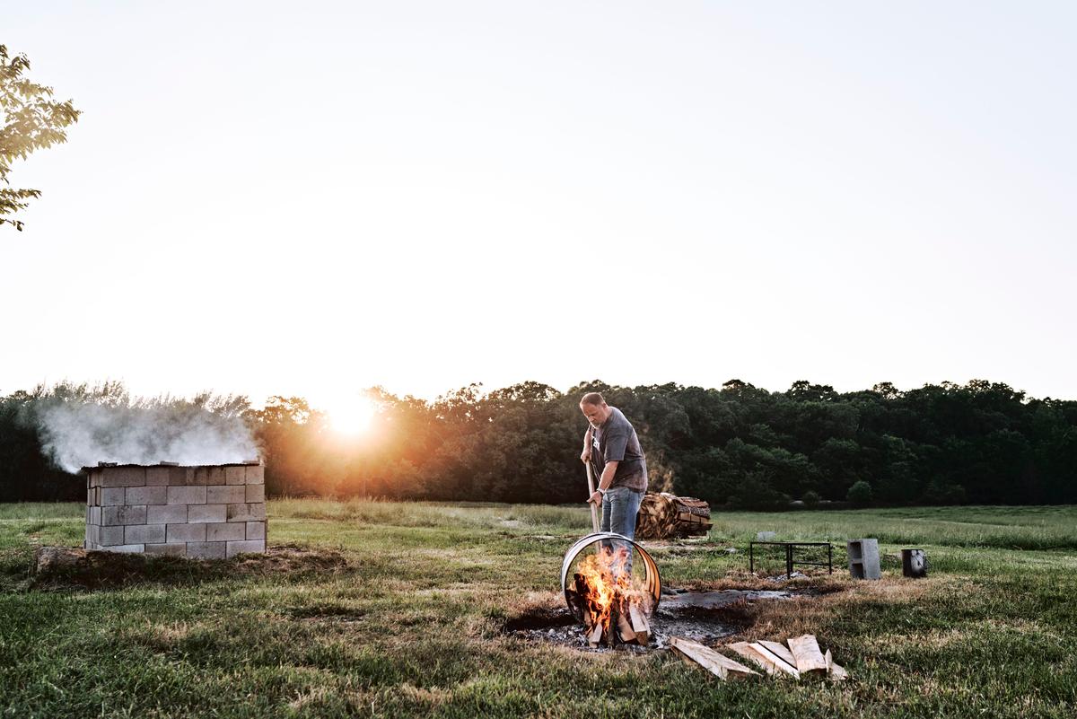A whole-hog cook needs a feeder fire to provide a steady supply of coals through the process. Martin prefers making a burn barrel. (Courtesy of Andrew Thomas Photography)